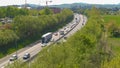 DRONE: Cars and truck cruise along the busy highway during afternoon rush hour. Royalty Free Stock Photo