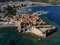 Drone cityscape view of Budva town with the sea and harbor with docked boats in Montenegro