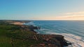 Drone coastal nature sunny day. Blue sea waves splashing low greenery shoreline Royalty Free Stock Photo