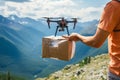 A drone delivers food, drinks or medicine in cardboard packaging to the mountains. A man receives an order or assistance