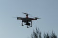 Drone with digital camera flying in the blue sky. Royalty Free Stock Photo
