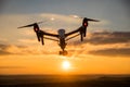 Drone with digital camera flying in sky over field on sunset