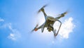 Drone DJI Phantom 4 in flight. Quadrocopter against the blue sky