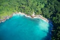 Drone field of view of secret cove with turquoise blue water meeting the forest on secluded island of Mahe, Seychelles