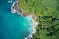 Drone field of view of turquoise water coastline meeting forest Mahe, Seychelles