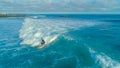 DRONE: Fit male surfing epic barrel waves near rocky island on a sunny day