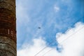 The drone flies near the ruins and the high water tower. Against the background of the summer sky with clouds