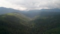 Drone flight above green tree-covered mountain slopes