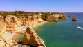 Drone flight over crowdy Praia de Marinha in Portugal