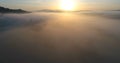 Drone flight over foggy vally during sunrise.