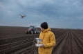 Drone flying above tractor in field