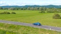 DRONE: Flying along an autonomous car driving down the straight country road. Royalty Free Stock Photo