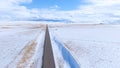 DRONE: Flying along a long straight road leading through the wintry Montana Royalty Free Stock Photo