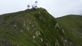 Drone flying towards to peak of mountain with satellite towers