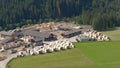 DRONE: Flying around a lumberyard full of organized stacks of planks and logs.