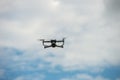 Drone flying in a blue sky, The grey unmanned aerial vehicle on cloudy sky background Royalty Free Stock Photo