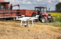 Drone in front of tractor and combine harvester in field Royalty Free Stock Photo