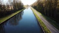 Drone flying low over river or canal and forest in Belgie