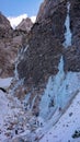 DRONE: Flying near a mountain where ice climbers scale up a frozen waterfall