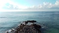 Drone flying over beachhouse and breakwater ocean