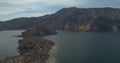 Drone flying over an island in a lake with mountains in the background