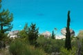 DRONE: Flying over the mediterranean greenery above the secluded sandy beach.