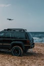 Drone flying over an offroad vehicle on the beach