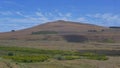 DRONE: Flying towards the steep grassy hill on world famous Easter Island.