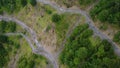 Drone flying towards to curvy narrow road on the hill with cars on it