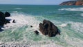 Drone foamy waves rolling on stony shoreline in slow motion. Sea washing coast Royalty Free Stock Photo