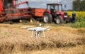 Drone in front of tractor and combine harvester in field Royalty Free Stock Photo