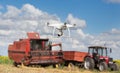 Drone in front of tractor and combine harvester in field Royalty Free Stock Photo