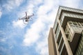 Drone with high resolution digital camera flying over city . An aerial view of a flying multi-copter with raised landing gears and Royalty Free Stock Photo