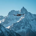 A drone hovers in the foreground against a backdrop of snow-covered mountains. Royalty Free Stock Photo
