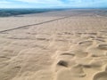 Drone image, international border wall through the Imperial Sand Dunes in California