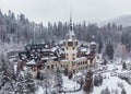 Drone landscape view of the Peles Castle in Sinaia, Romania and the Carpathian Mountains in winter Royalty Free Stock Photo