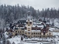 Drone landscape view of the Peles Castle in Sinaia, Romania and the Carpathian Mountains in winter Royalty Free Stock Photo