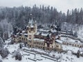 Drone landscape view of the Peles Castle in Sinaia, Romania and the Carpathian Mountains in winter Royalty Free Stock Photo