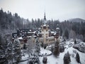 Drone landscape view of the Peles Castle in Sinaia, Romania and the Carpathian Mountains in winter Royalty Free Stock Photo