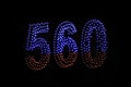 Drone light shows on black night sky background. A figure of the number five hundred and sixty, six, five, zerro, 560