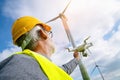 Drone operated by construction worker inspecting wind turbine Royalty Free Stock Photo