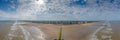 Drone panorama over the beach of the Belgian coastal town of Middelkerke at low tide with breakwaters during the day
