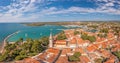 Drone panorama over the roofs of the Croatian coastal town of Novigrad with harbor and church during daytime