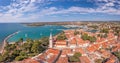 Drone panorama over the roofs of the Croatian coastal town of Novigrad with harbor and church during daytime