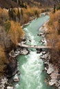 A drone photo of an autumn landscape over a blue rushing river with dangerous rapids