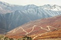 Drone photo of a curvy hilly road with snow covered Himalayas mountains in the background in Ladakh, India Royalty Free Stock Photo