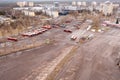 Drone photography of city bus park, lots of parked buses and cityscape during spring morning