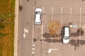 Drone photography of a close up of a few parked cars in a parking lot near a big shopping center Royalty Free Stock Photo