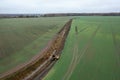 Drone photography of excavator cleaning drainage ditch in an agriculture field during autumn morning