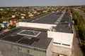 Drone photography of large logistical warehouse and office rooftop with solar energy modules